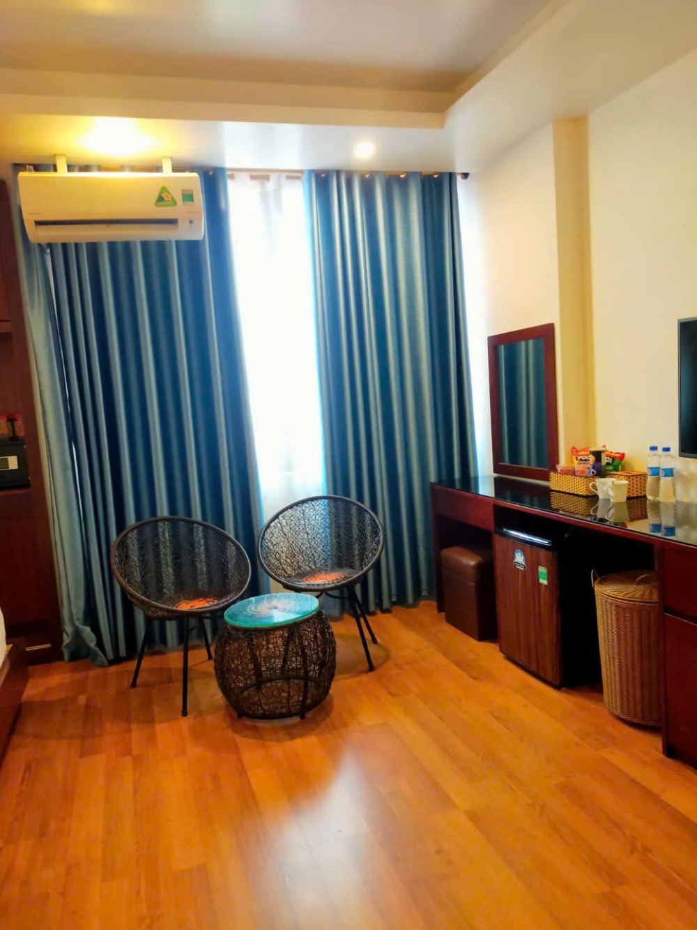 Seating area in a Camellia Hotel room with blue curtains