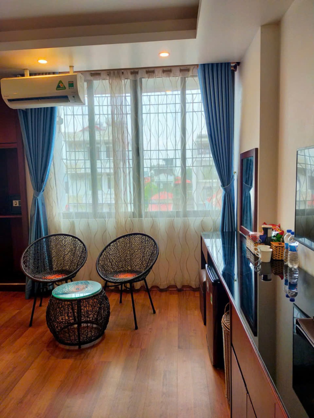 Room detail with soft blue curtains and rattan chairs