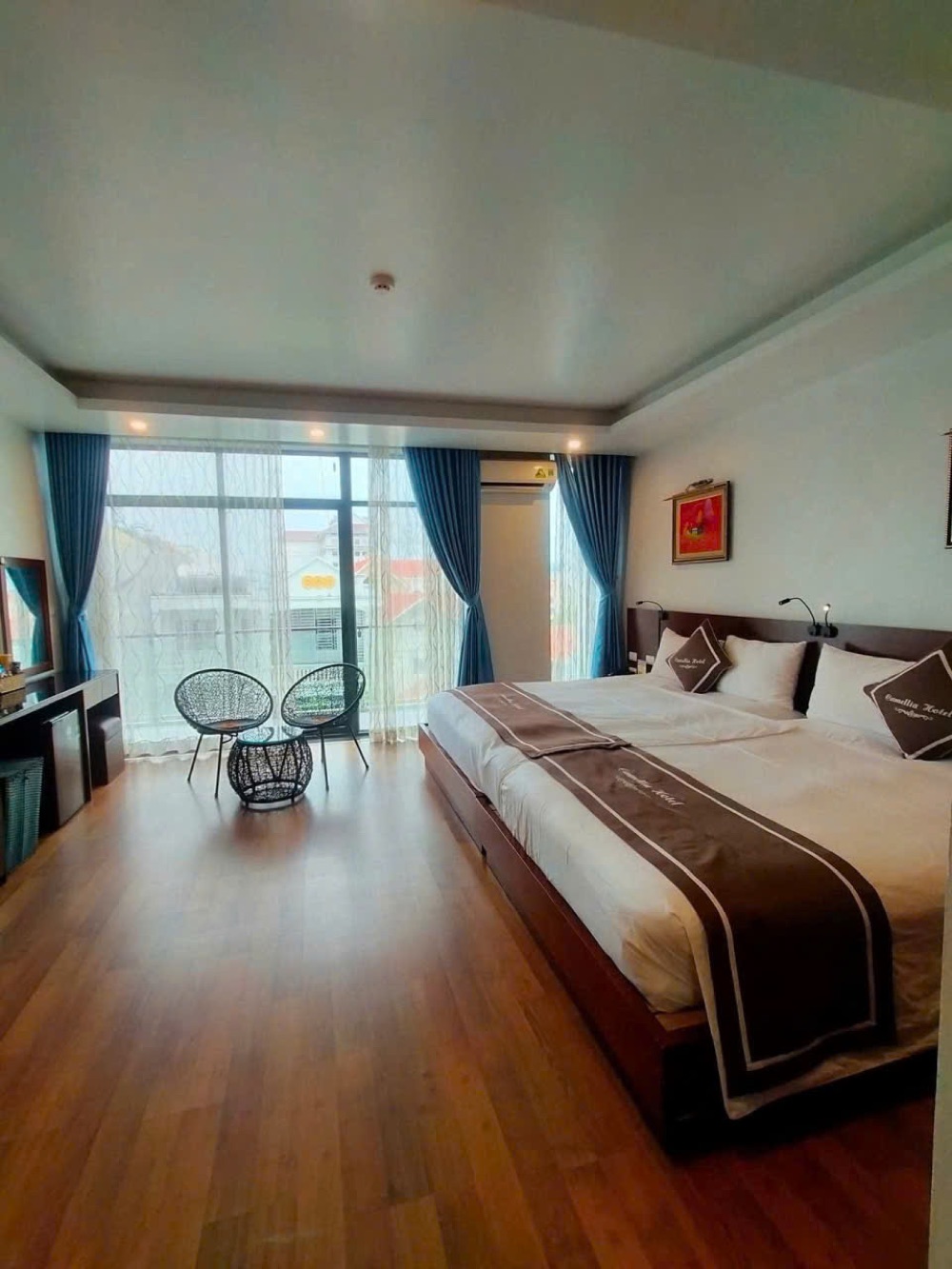 Spacious Camellia Hotel suite with king bed and balcony